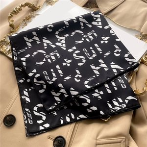 Detail of geometric pattern silk scarf with text print on vintage golden tray