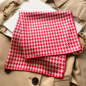 Detailed view of red and white houndstooth silk scarf with refined overlock edge stitching