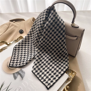 Houndstooth satin silk scarf tied to a beige handbag with a minimalist aesthetic style