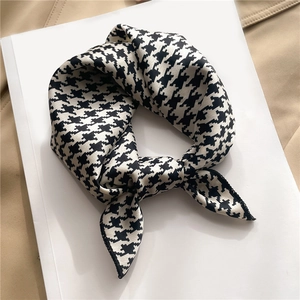 Elegant houndstooth pattern satin silk scarf displayed on a minimalist beige background