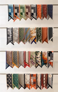 Detailed display of assorted polka dot and patterned silk scarves on metal racks