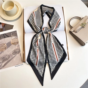 Elegant houndstooth neck scarf for women styled on an open book with handbag and coffee