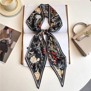 Detail of silk twilly scarf featuring crane patterns and striped edges on books