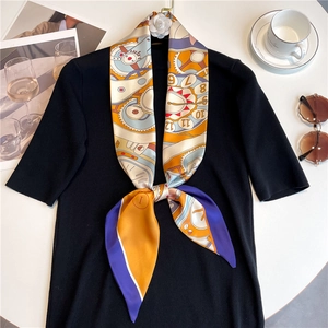 Detail of a thin silk twilly scarf with vintage clock print tied on a black knit collar