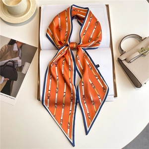 Polka dot silk scarf tied in a bow on a book showing its smooth fabric and pointed ends