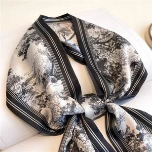 Detail of a vintage black and white Toile de Jouy silk scarf tied over a magazine