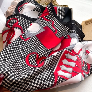 Detail of houndstooth silk scarf with red ribbon accents and fashion illustration print