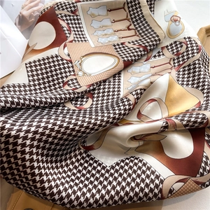 Detail of silk scarf with houndstooth pattern and vintage fashion illustrations
