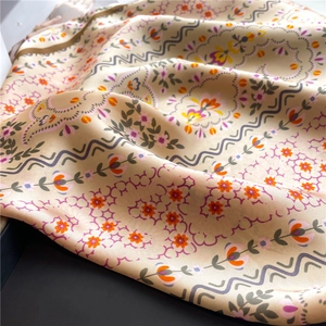 Detailed close-up of floral satin scarf texture showing elegant patterns and silky luster