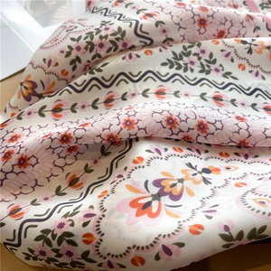 Detail of floral silk scarf showing smooth texture and elegant pastel flower patterns