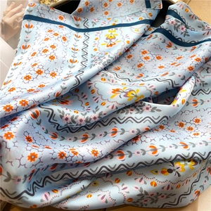 Floral sky blue silk scarf with colorful flower patterns and smooth glossy finish