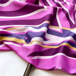Macro shot of silk satin scarf featuring abstract geometric patterns and smooth texture