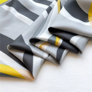 Detail of geometric pattern twill silk scarf with black, grey and yellow color blocks