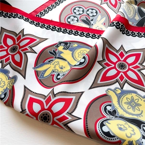 Detalle de un pañuelo de seda con estampados de conejos y motivos geométricos vibrantes