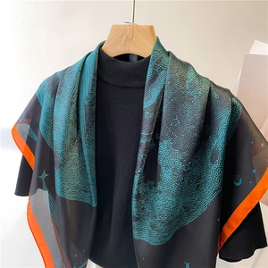 Détail d'un foulard en soie imprimé abstrait sarcelle avec bordure orange éclatante