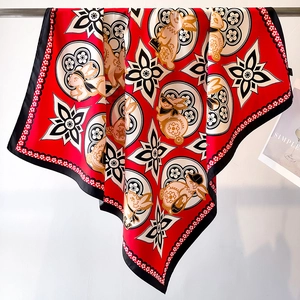 Primer plano de un gran pañuelo de seda roja con motivos de conejo del zodíaco y bordes negros