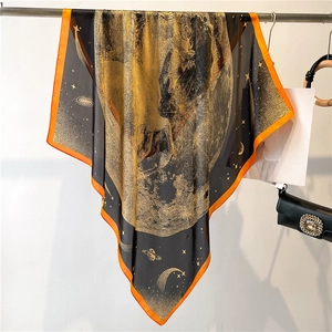 Détail d'un foulard en soie avec des motifs dorés de lune et d'étoiles sur fond noir