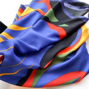 Close-up of luxury silk scarf with abstract patterns in blue, orange and yellow colors