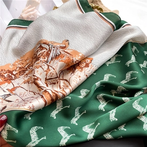 Detail of silk-like scarf featuring zebra stripes and forest pattern in emerald and cream