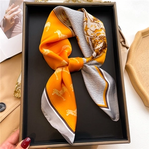 Silk scarf with zebra pattern and orange blocks in a gift tray with fashion accessories