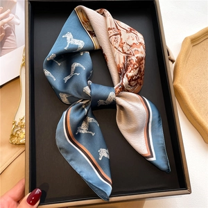 Detailed close-up of blue and tan silk-feel scarf with zebra and jungle prints