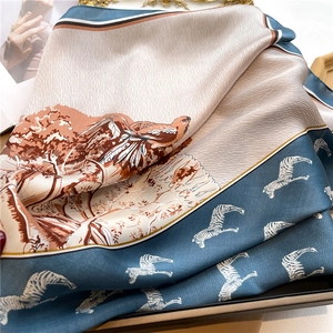 Detail of silk scarf showing nature prints with birds, trees, and zebra pattern borders