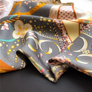 Detail of silk-like scarf with hot air balloon print and orange vintage patterns