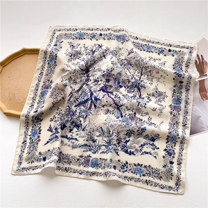 Detail of Toile de Jouy silk scarf with blue bird and floral patterns on white satin fabric