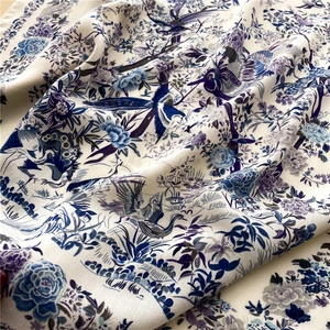 Close-up of silk scarf with floral bird print showing premium twill fabric texture