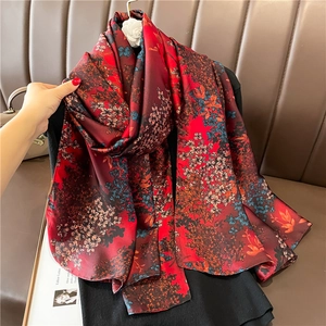 Close-up of luxury dark red floral print scarf with elegant satin silk texture detail