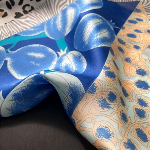 Detailed view of the silky texture and elegant floral pattern on the square scarf