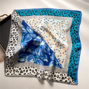Detail showing mixed animal print and floral patterns on silk scarf with smooth texture