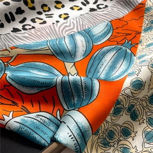 Macro detail of silk scarf featuring leopard print, zebra patterns and floral artwork
