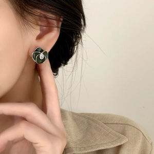 Retro deep green enamel flower earrings with water drop zircon on model in camel coat