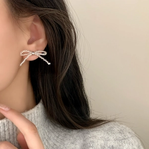 Elegant beaded bow earrings with transparent abacus beads on a female model