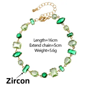 Macro detail of gold-tone bracelet with green zircon stones and adjustable lobster clasp