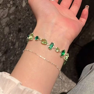 Elegant layered bracelet set with green zircon stones and silver beads on wrist
