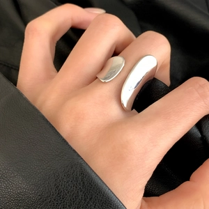 Minimalist silver asymmetric open ring with polished organic wrap design on a model