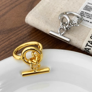Modern gold and silver link chain rings with OT toggle clasp shown in a lifestyle setup
