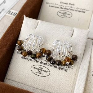 Detailed shot of tiger eye stone tassel earrings with 925 silver fan-shaped design