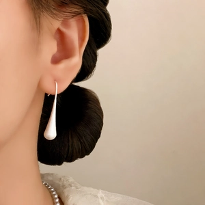 Minimalist matte white teardrop earrings on model with elegant vintage aesthetic