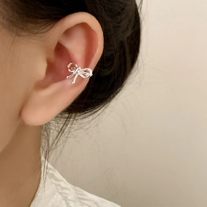 Silver bow ear cuff with twisted texture shown on ear for a minimalist jewelry look