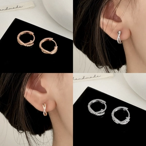 Boucles d'oreilles créoles torsadées croisées avec zircons en or et argent