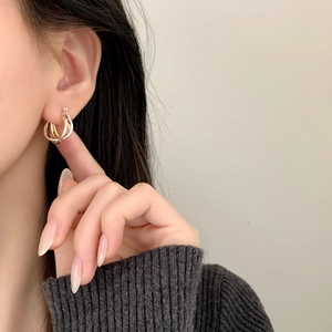 Orecchini a cerchio triplo intrecciati in oro e argento indossati da modella