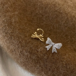 Bow-shaped ear bone clips with micro-set zircons in gold and silver finishes