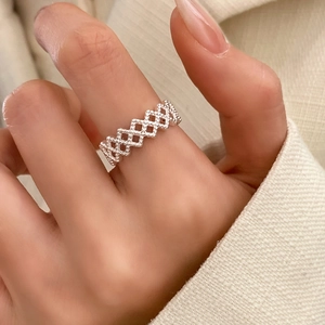 Silver open geometric lattice ring with hollow diamond pattern worn on finger