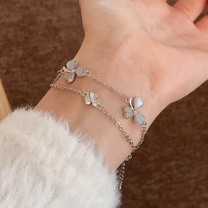 Double-layered silver bracelet with zircon petals and a blue cat-eye stone butterfly