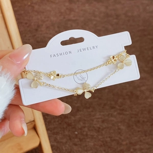 Double-layered gold bracelet featuring cat eye stone flower petals and pavé crystal accents