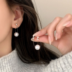 Minimalist French style long pearl earrings featuring silver beads on a female model