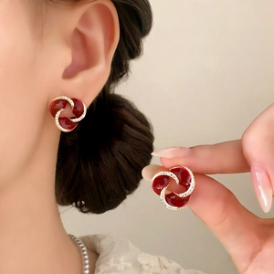Retro-Ohrstecker aus dunkelroter Emaille mit glitzernden Zirkonen an einem Model